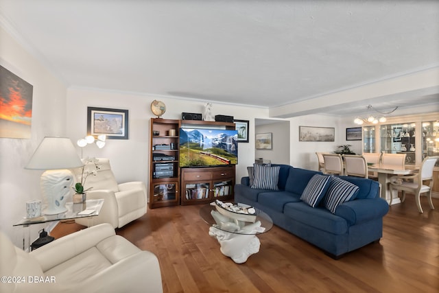 living room with dark wood-type flooring, an inviting chandelier, and ornamental molding