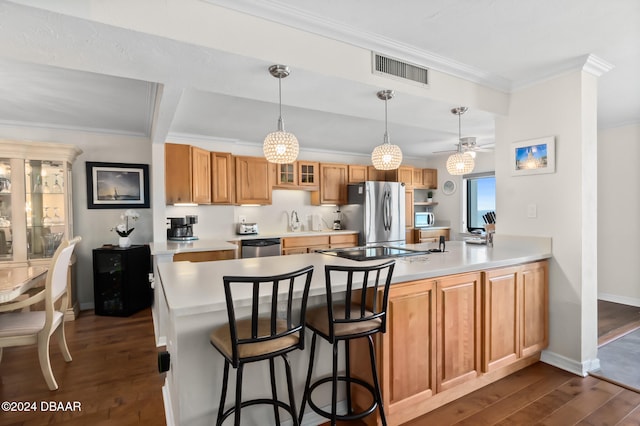 kitchen with kitchen peninsula, dark hardwood / wood-style flooring, a breakfast bar, and appliances with stainless steel finishes