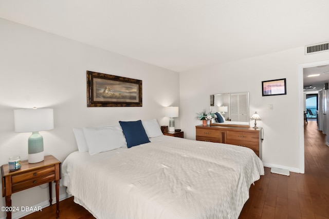 bedroom with dark hardwood / wood-style floors