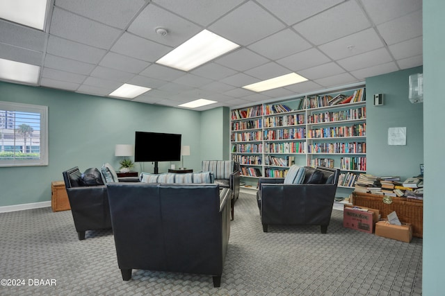 carpeted living room with a drop ceiling