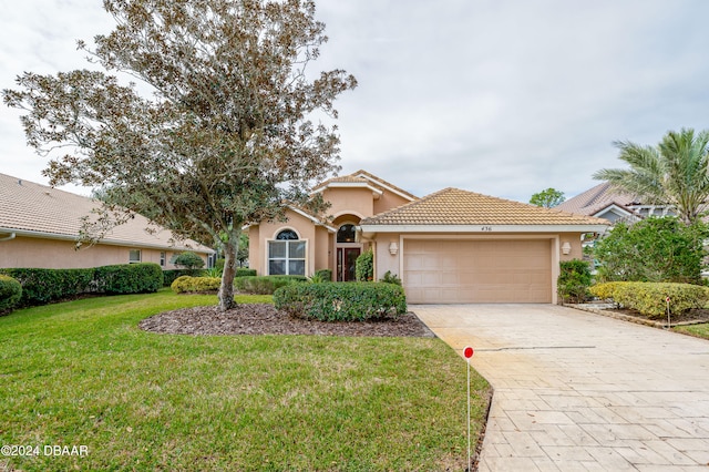 mediterranean / spanish house with a garage and a front yard