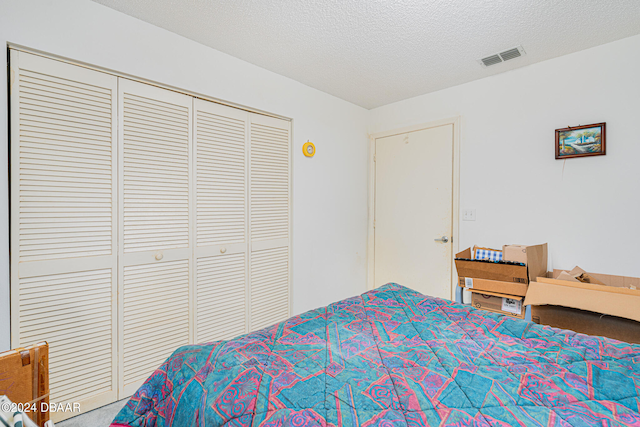 bedroom featuring a textured ceiling and a closet