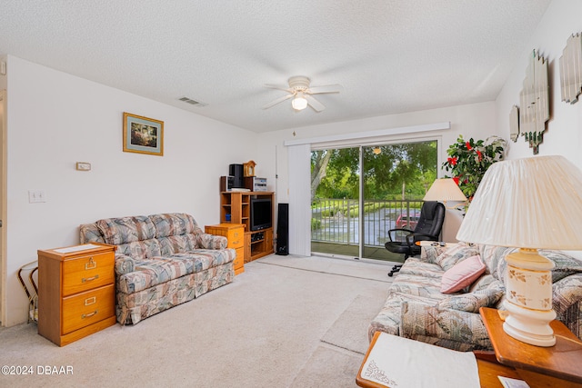 carpeted living room featuring a textured ceiling and ceiling fan