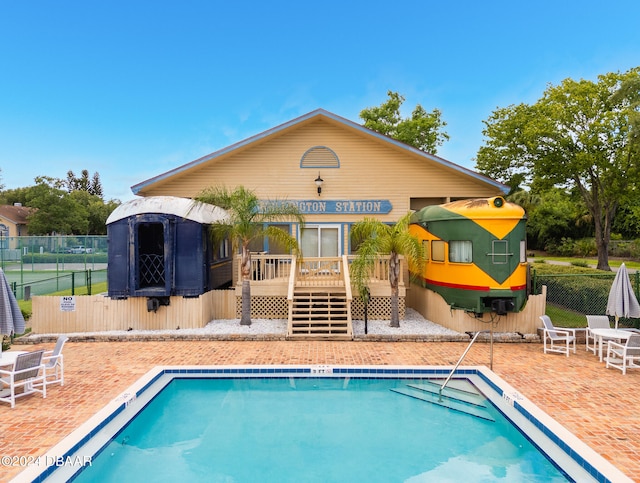 view of swimming pool featuring a wooden deck and a patio