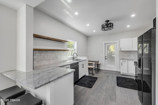 182 Howes St, Oak Hill, FL 32759 - kitchen with white cabinetry, black refrigerator with ice dispenser, stainless steel dishwasher, a sink, and a peninsula