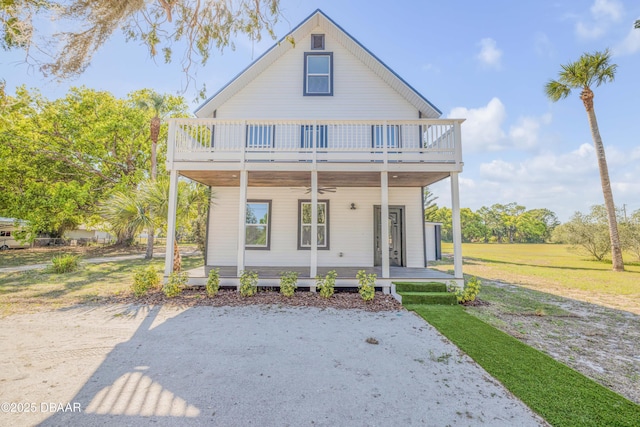 182 Howes St, Oak Hill, FL 32759 - view of front of home with a front yard, a ceiling fan, a balcony, and a porch