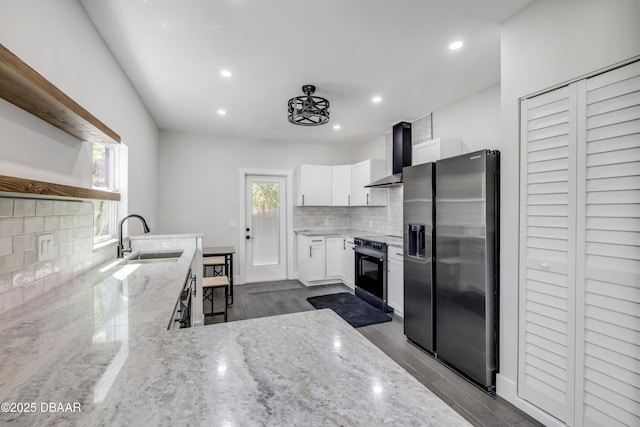 182 Howes St, Oak Hill, FL 32759 - kitchen featuring appliances with stainless steel finishes, a sink, open shelves, light stone counters, and wall chimney range hood