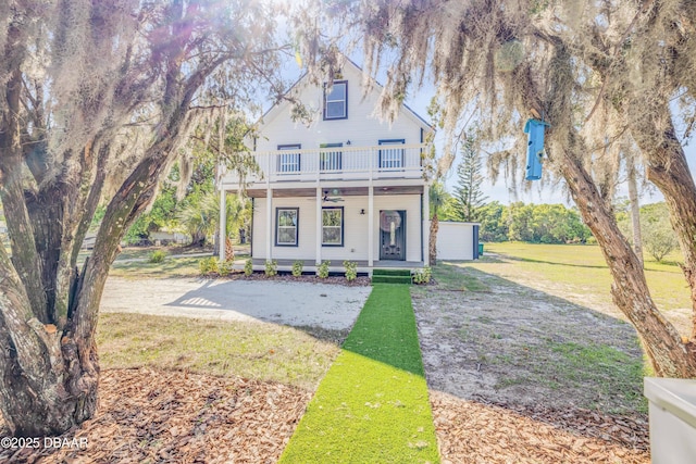 182 Howes St, Oak Hill, FL 32759 - view of front of home featuring a balcony, covered porch, a front lawn, and a ceiling fan