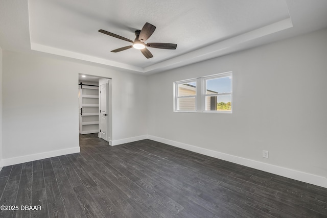 182 Howes St, Oak Hill, FL 32759 - spare room with baseboards, ceiling fan, dark wood-type flooring, and a raised ceiling