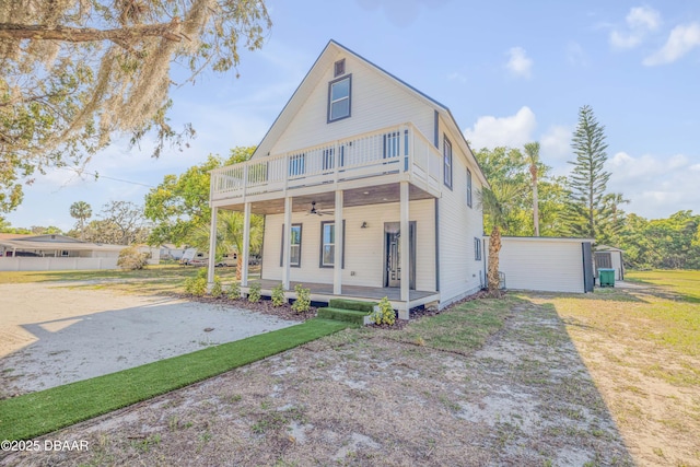 182 Howes St, Oak Hill, FL 32759 - view of front of property featuring an outdoor structure, fence, a balcony, a front lawn, and ceiling fan