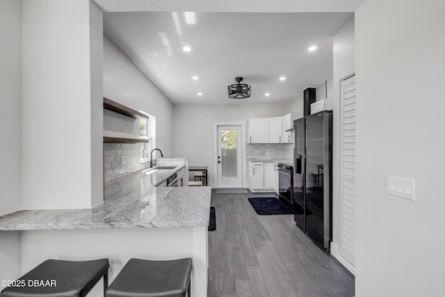 182 Howes St, Oak Hill, FL 32759 - kitchen with a sink, open shelves, white cabinetry, black appliances, and dark wood-style flooring