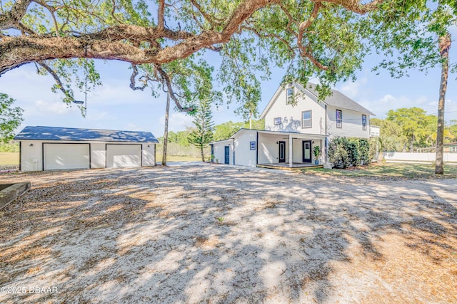 182 Howes St, Oak Hill, FL 32759 - view of front of property with an outdoor structure, a porch, and a detached garage