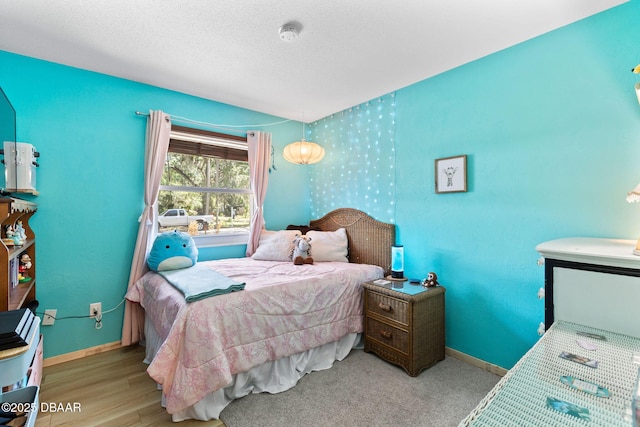 292 Fir St, Ormond Beach, FL 32174 - bedroom with baseboards, wood finished floors, an accent wall, and wallpapered walls