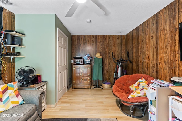 292 Fir St, Ormond Beach, FL 32174 - miscellaneous room featuring light wood-style flooring, wood walls, a ceiling fan, and a textured ceiling