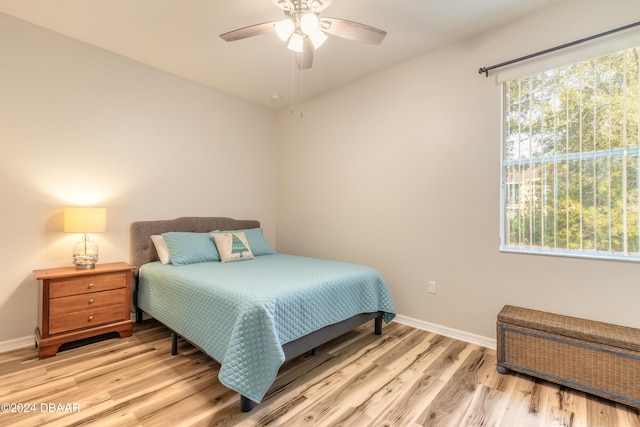 bedroom with light hardwood / wood-style flooring, multiple windows, and ceiling fan