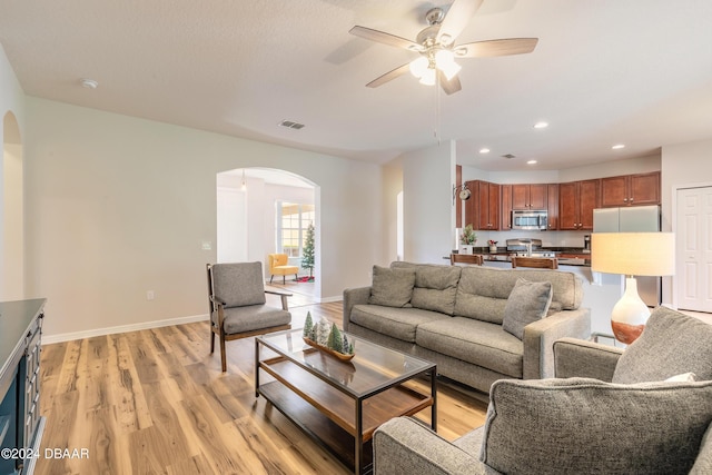 living room featuring ceiling fan and light hardwood / wood-style flooring