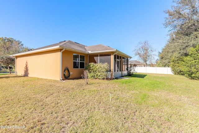 back of house featuring a sunroom and a yard