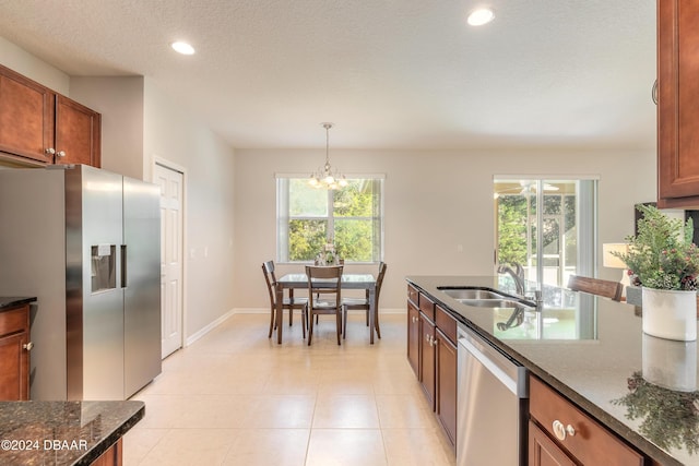 kitchen featuring hanging light fixtures, a healthy amount of sunlight, sink, and stainless steel appliances