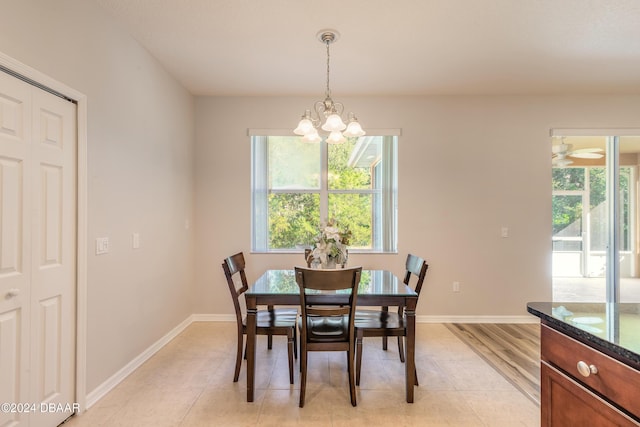 tiled dining space with ceiling fan with notable chandelier and plenty of natural light