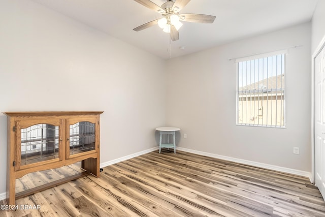 spare room with light wood-type flooring and ceiling fan