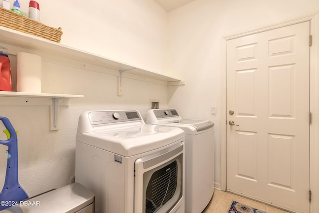 laundry room with washing machine and dryer and light tile patterned flooring