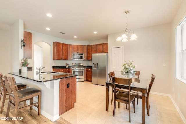 kitchen featuring a healthy amount of sunlight, kitchen peninsula, sink, and appliances with stainless steel finishes