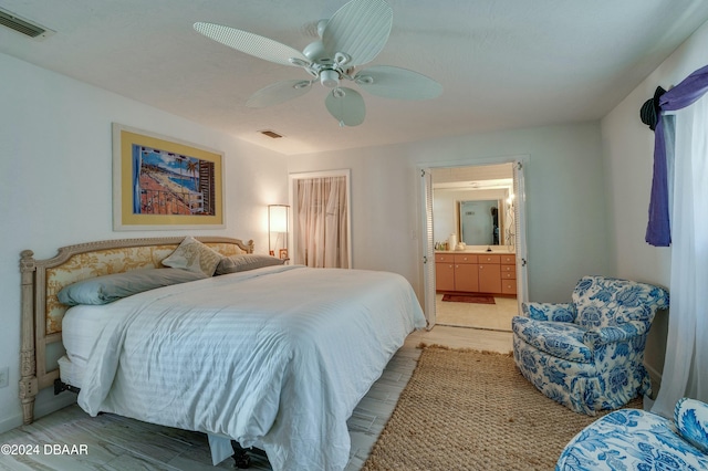 bedroom with light wood-type flooring, connected bathroom, and ceiling fan