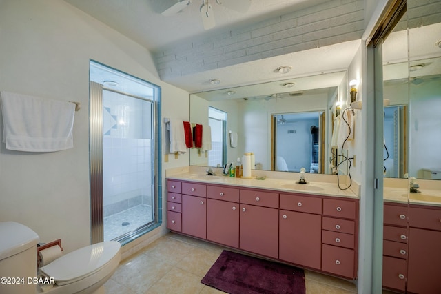 bathroom with tile patterned floors, toilet, vanity, a shower with door, and ceiling fan