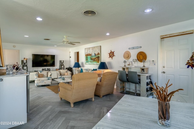 living room with ceiling fan and dark parquet floors