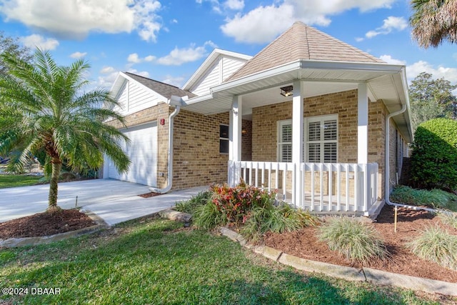 view of front of house with brick siding, a porch, an attached garage, and driveway