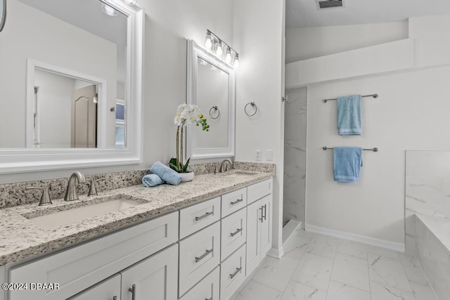 full bath featuring double vanity, marble finish floor, baseboards, and a sink