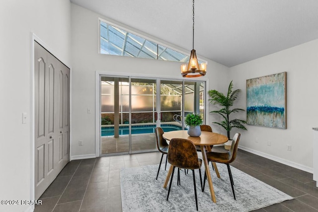 dining space with tile patterned floors, high vaulted ceiling, and baseboards