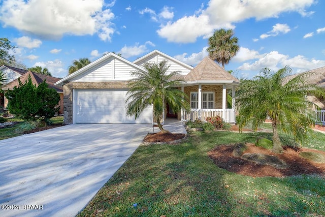 view of front of home with brick siding, a front lawn, a porch, concrete driveway, and a garage