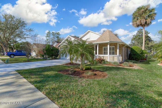 view of front of property with a front yard, brick siding, covered porch, and driveway