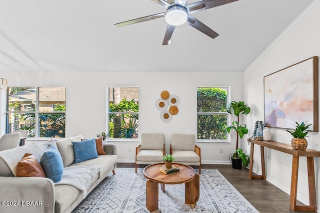 living room with wood finished floors, a ceiling fan, baseboards, and vaulted ceiling