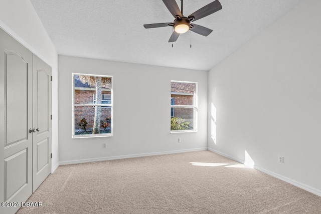 unfurnished bedroom with baseboards, a textured ceiling, ceiling fan, and carpet flooring