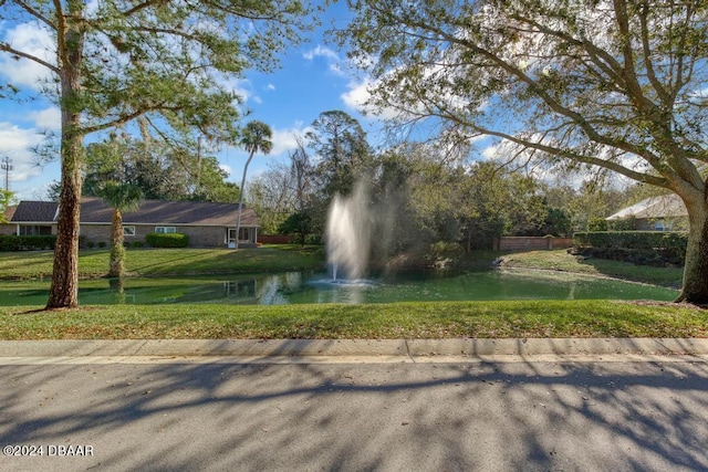 surrounding community featuring a lawn and a water view