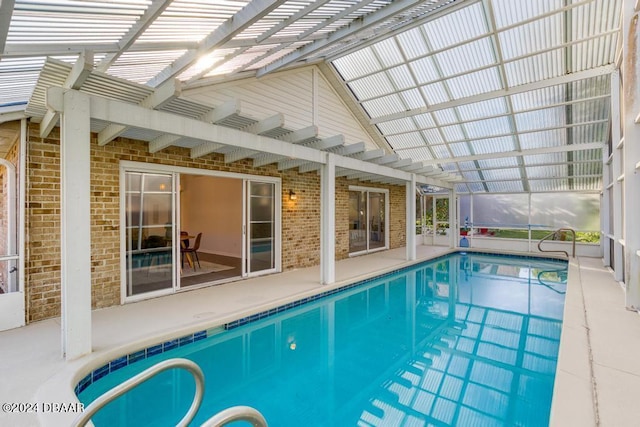 indoor pool with glass enclosure, a patio, and a pergola