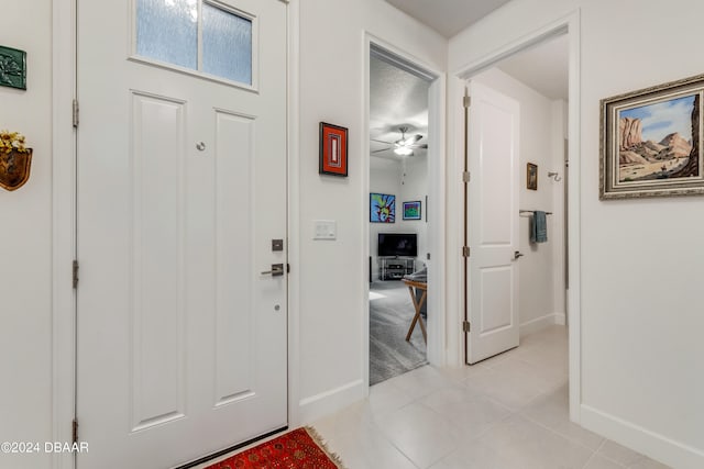 tiled entrance foyer with ceiling fan