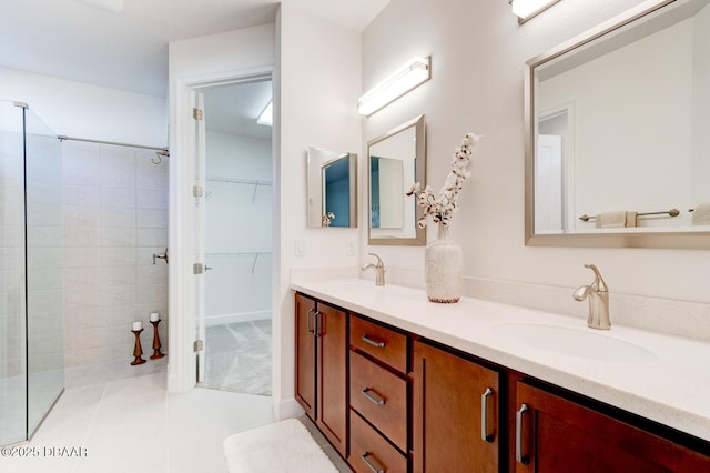 bathroom with tile patterned floors, vanity, and a tile shower