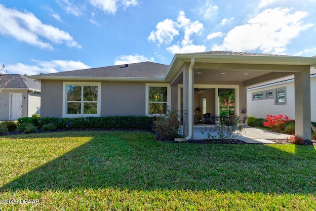 rear view of house with a patio and a lawn