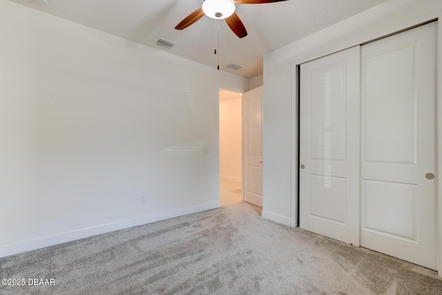 unfurnished bedroom featuring light colored carpet, ceiling fan, and a closet