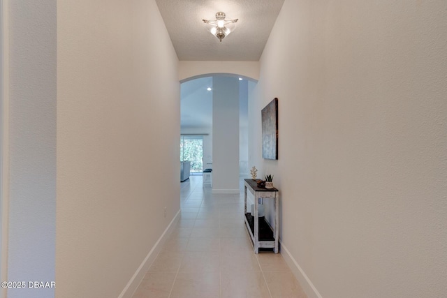 hall with light tile patterned floors and a textured ceiling