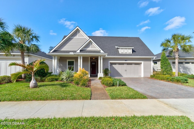 view of front of home featuring a garage, covered porch, and a front lawn