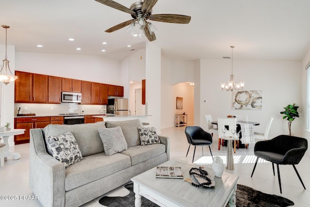 living room with ceiling fan with notable chandelier, high vaulted ceiling, and light tile patterned flooring