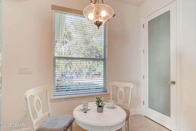 dining area with light tile patterned flooring and a chandelier