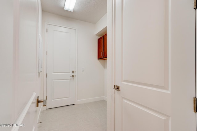 interior space with light tile patterned floors and a textured ceiling