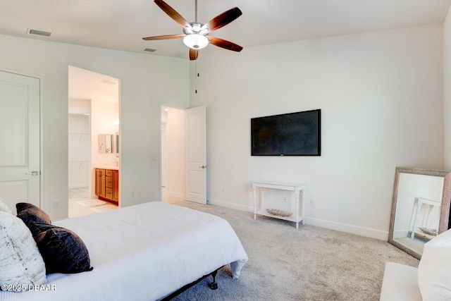 bedroom featuring vaulted ceiling, connected bathroom, light colored carpet, and ceiling fan