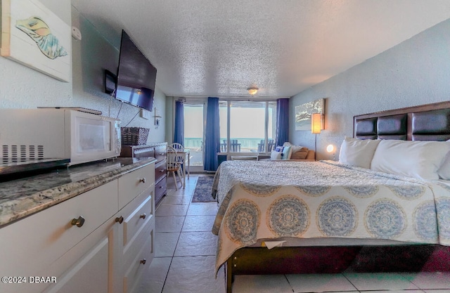 tiled bedroom featuring a textured ceiling