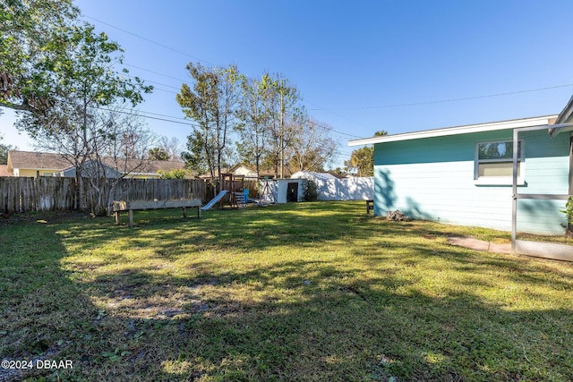 view of yard featuring a playground and a shed